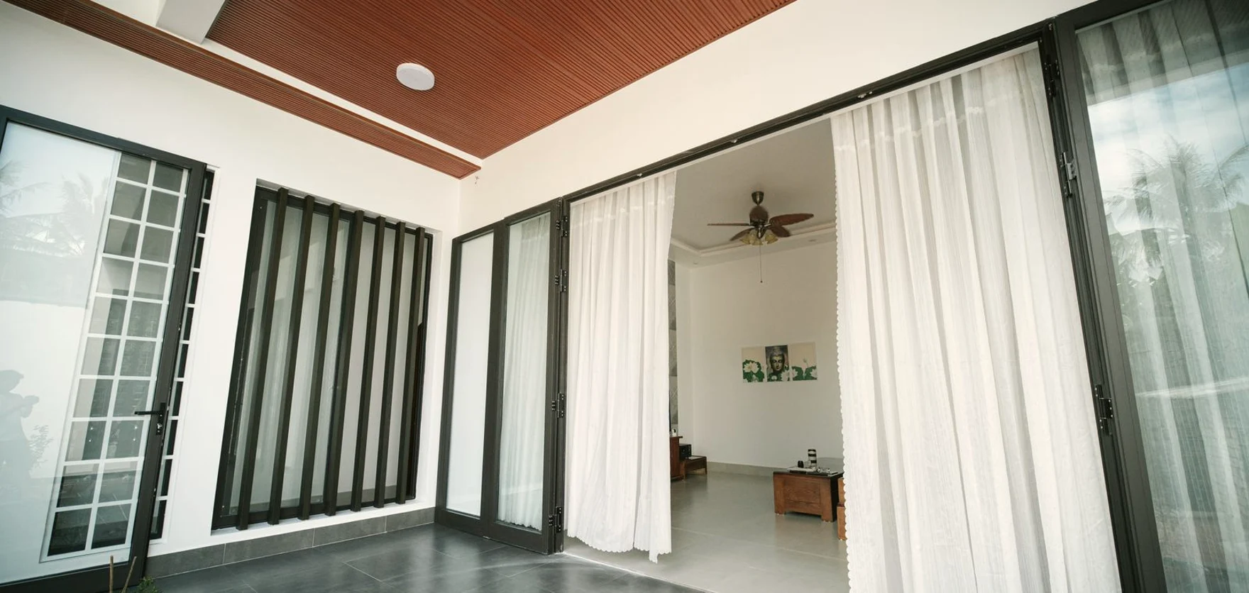 Black-framed aluminium and glass wall opening onto a terrace